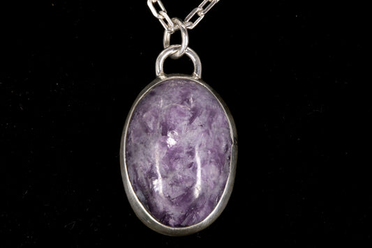 Purple Lepidolite pendant on a silver chain against a black background