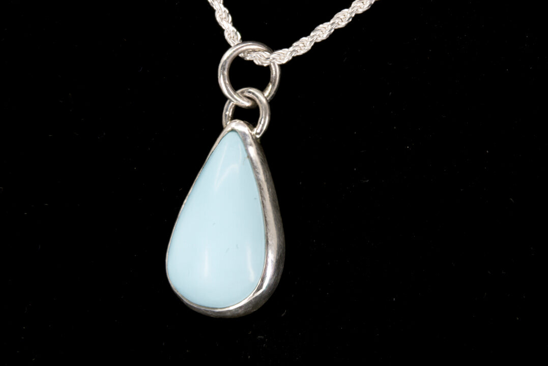 Teardrop-shaped pendant on a black background left side