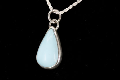 Teardrop-shaped pendant on a black background left side