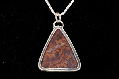 Rooster Tail Agate Triangle Pendant set in sterling silver on a black background open back view