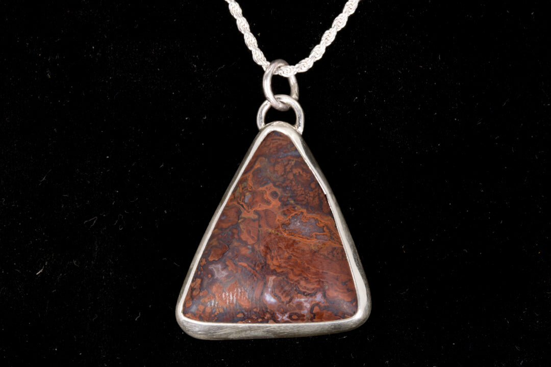Rooster Tail Agate Triangle Pendant set in sterling silver on a black background