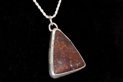 Rooster Tail Agate Triangle Pendant set in sterling silver on a black background