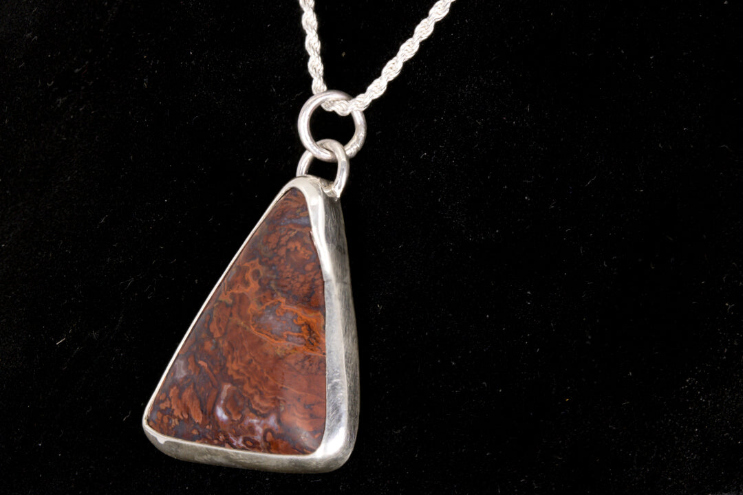 Rooster Tail Agate Triangle Pendant set in sterling silver on a black background